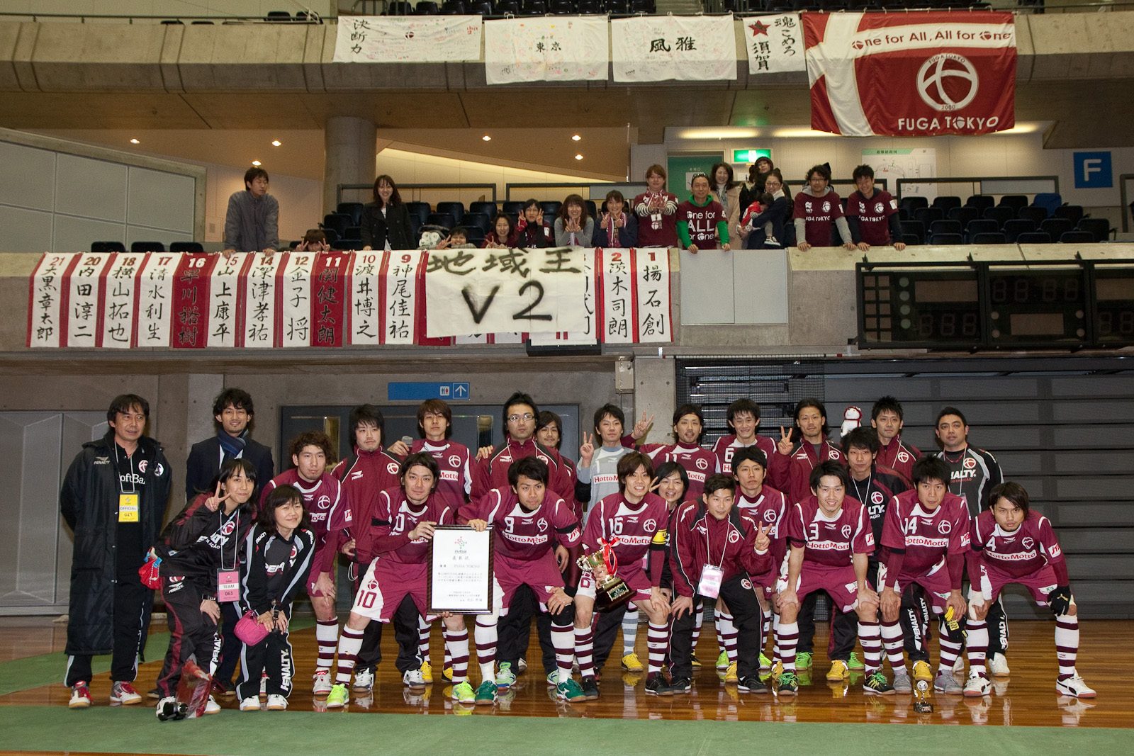 優勝後、「地域王 V2」の横断幕と集合写真